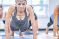 Senior woman doing a plank exercise on a yoga mat